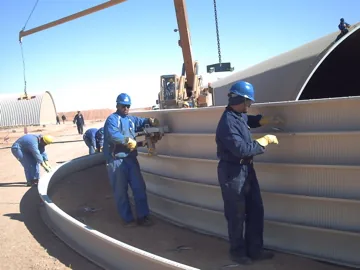 Workers assembling curved K-Span steel panels